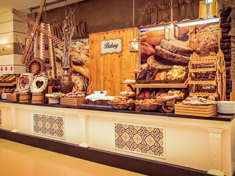 Buffet con una variedad de productos horneados dulces y panes en un mostrador decorado.