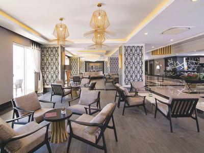 Elegantní, moderní hotelová lounge s křesly a stylovými závěsnými světly.