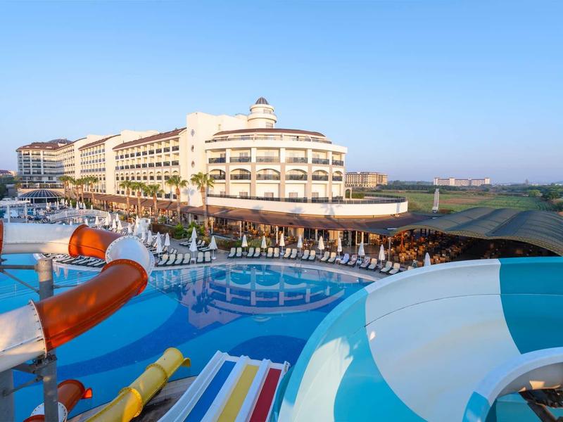 Hotel s velkým vodním parkem, bazény s tobogány a lehátky, modrá obloha