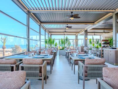 Světla moderní restaurace s velkými okny s výhledem na pláž.