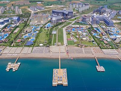 Gran complejo hotelero con varias piscinas, áreas de playa y muelles hacia el mar.