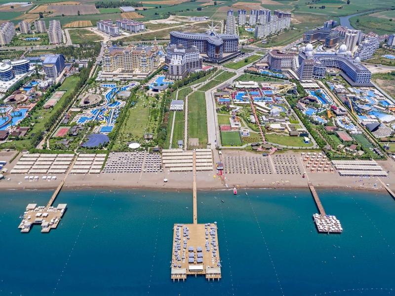 Gran complejo hotelero con varias piscinas, áreas de playa y muelles hacia el mar.