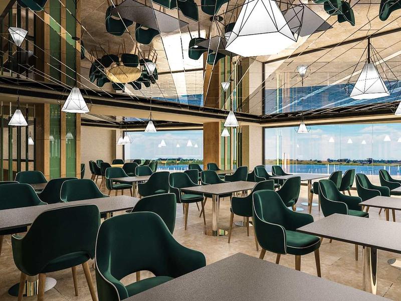 Modern dining room with green chairs and large windows showing mountain views