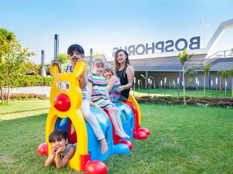 Children playing on a colorful slide outdoors in sunny weather