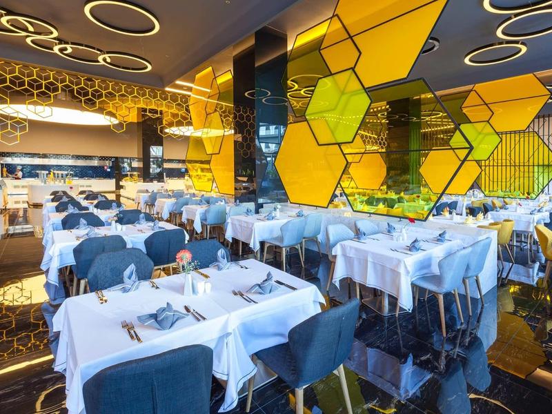 Modern restaurant with white tablecloths and yellow wall decorations