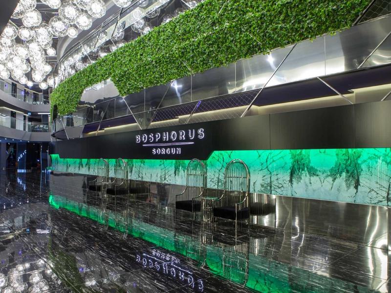 Modern hotel lobby with green wall and shiny black surfaces