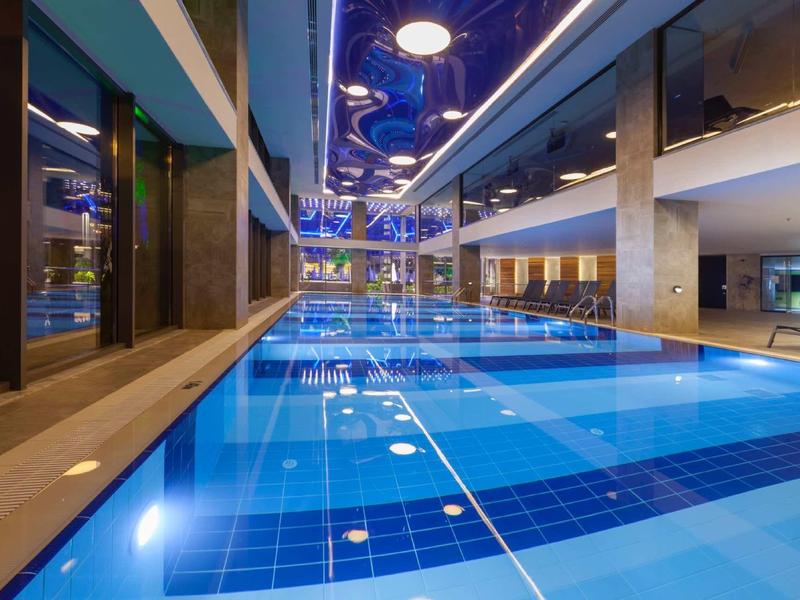 Modern indoor pool with blue tiled lanes and bright ambiance in a hotel.