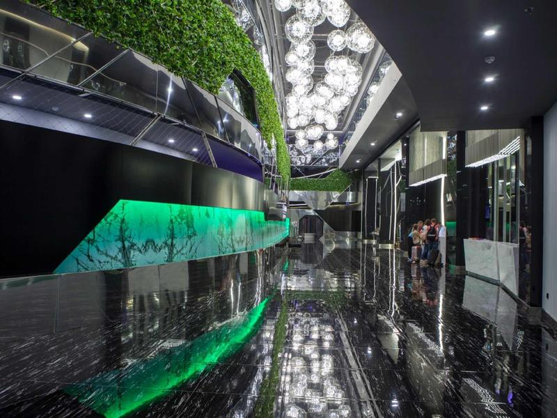 Luxurious hotel hallway with glossy black marble floor and innovative LED lighting.