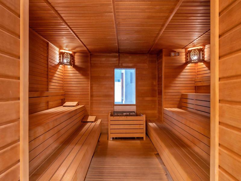 Een gezellige houten saunaruimte met banken aan beide zijden en een raam aan het einde.