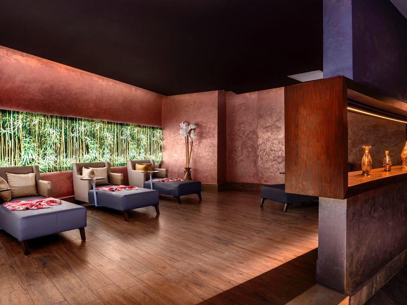 Elegante hotel-lounge met comfortabele stoelen, houten vloer en sfeerverlichting.