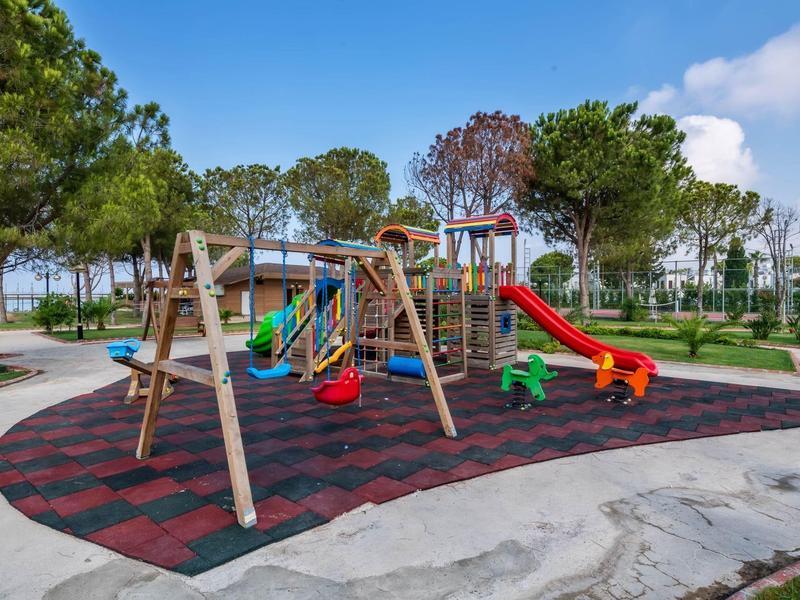 Kleurrijke speeltuin met glijbanen en schommels in een park op een zonnige dag