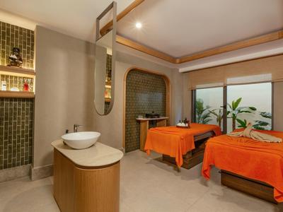 Nowoczesny pokój zabiegowy spa z dwoma łóżkami do masażu i ciepłym oświetleniem.