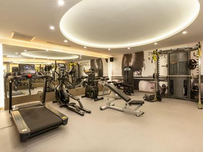Salle de sport moderne avec équipements d'entraînement et éclairage doux dans un hôtel.