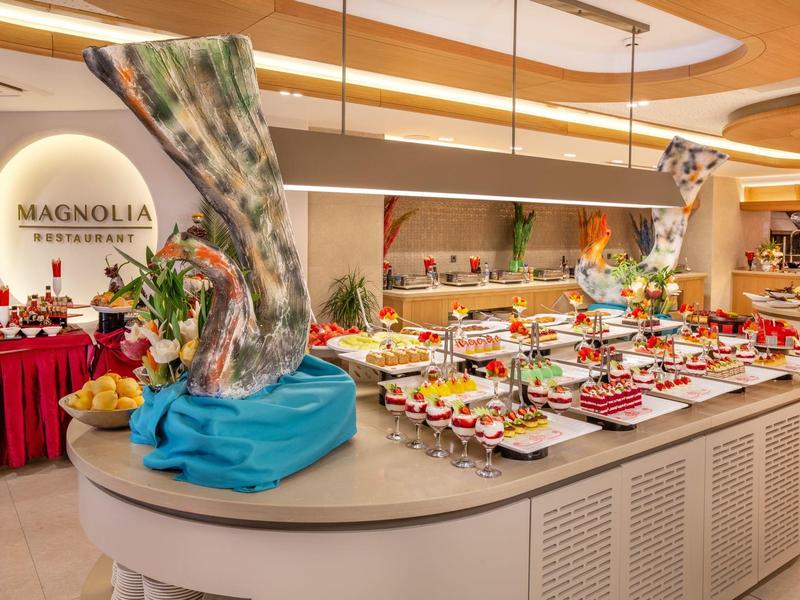 Elegancko przygotowany bufet z różnorodnymi słodkimi i wytrawnymi potrawami w restauracji Magnolia.