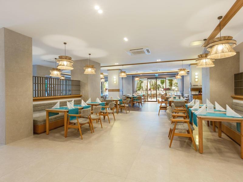 Elegancka, jasna restauracja z wygodnymi drewnianymi meblami i nowoczesnymi lampami do relaksującego posiłku.