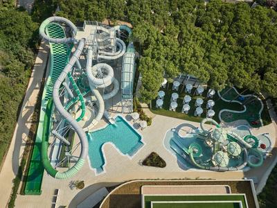 Großes Wasserpark-Areal mit vielfältigen Rutschen und Pools, umgeben von dichtem Wald.