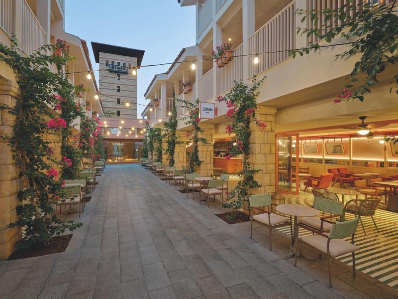 Innenhof eines modernen Hotels mit Sitzbereichen, Pflanzen und Beleuchtung