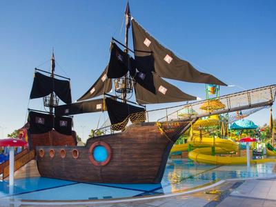 Velká pirátská loď v aquaparku s tobogány a modrou oblohou.