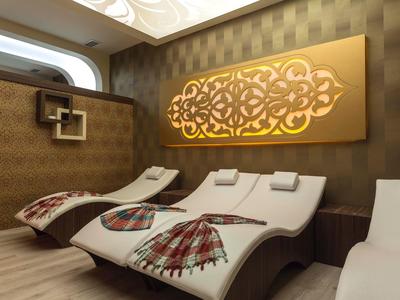 Relax zóna s zakřivenými lehátky a zlatou dekorací na zdi.