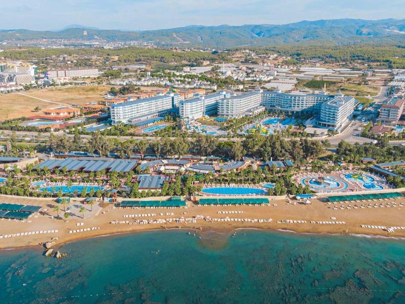 Letecký pohled na hotelový komplex u moře s plážemi a bazény.