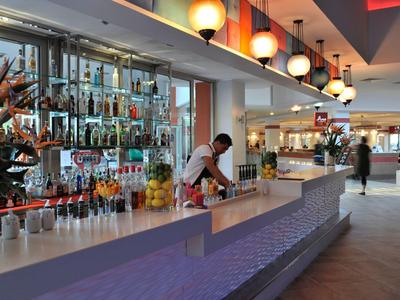 Nowoczesny bar hotelowy z barmanem i podświetlanym kontuarem.