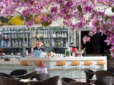 Nowoczesny bar z kwiatami na pierwszym planie i stylowymi miejscami do siedzenia w hotelu.