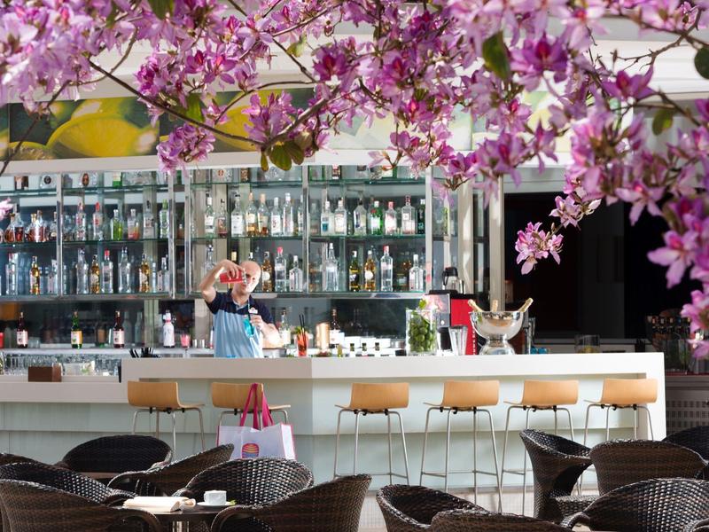 Nowoczesny bar z kwiatami na pierwszym planie i stylowymi miejscami do siedzenia w hotelu.