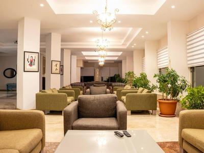 Modern hotel lobby with sofas, plants, and elegant lighting.