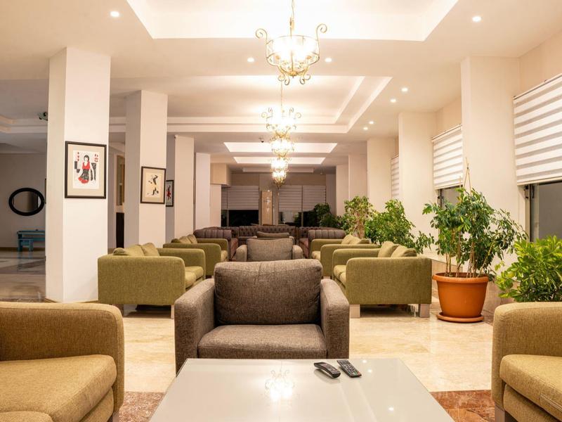 Modern hotel lobby with sofas, plants, and elegant lighting.