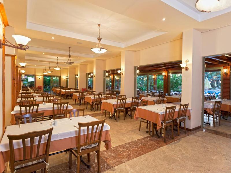 Bright spacious restaurant with set tables and wooden furniture.