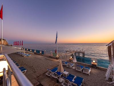 Spiaggia con lettini e ombrelloni al tramonto sul mare.