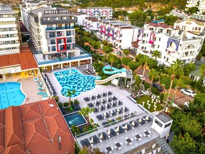 Aerial view of a hotel with outdoor pools, umbrellas, and sun loungers.