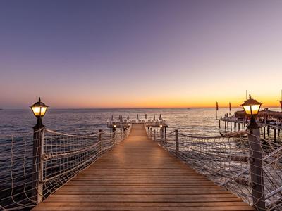 Pier with lanterns over the sea at sunset