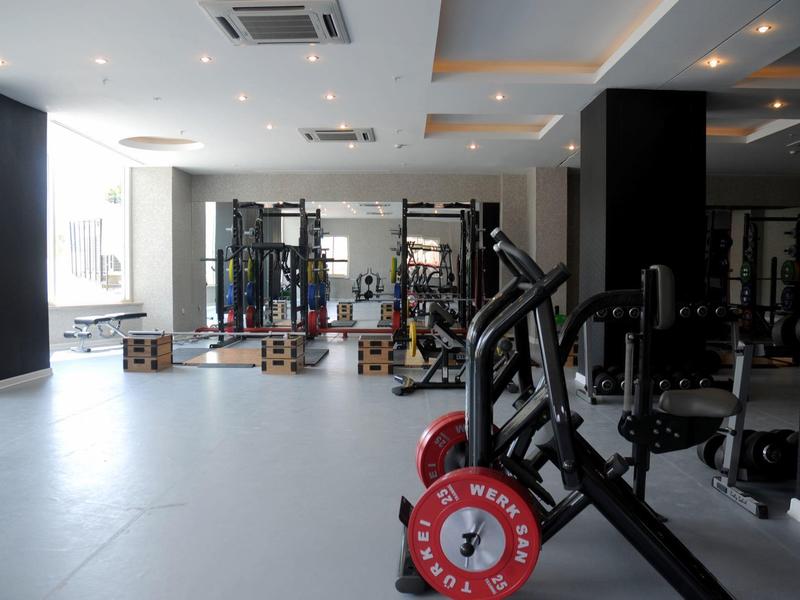 Gimnasio bien iluminado con pesas y equipos de entrenamiento en un hotel