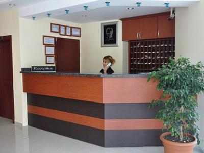 Réception avec des porte-clés et une femme derrière le comptoir dans un hôtel.