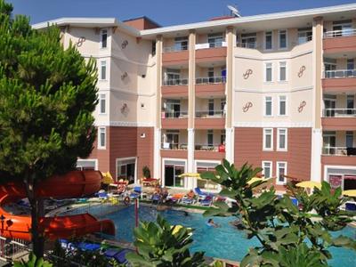 Budynek hotelu z wieloma piętrami i basenem na zewnątrz otoczonym roślinami