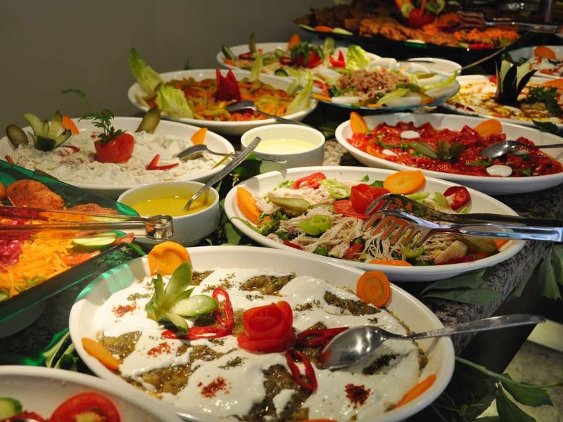 Buffet avec diverses entrées froides, joliment disposées sur des assiettes blanches.