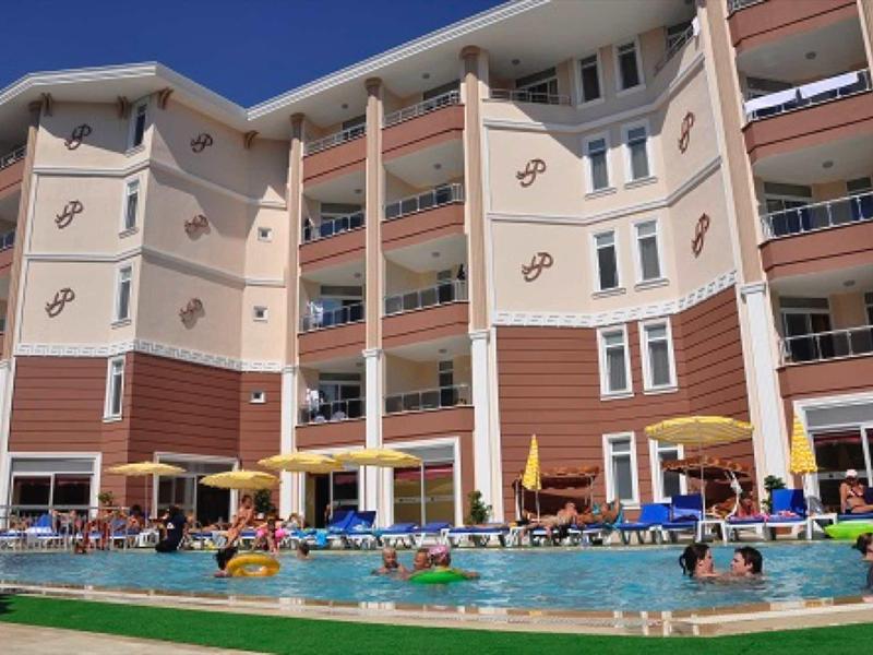 Hôtel à plusieurs étages avec chambres avec balcon et piscine extérieure, les clients se détendent dans l'eau et sur les chaises longues.