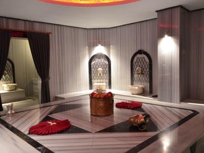Elegante Turkse hammam met marmeren bekleding en traditionele wasbakken.