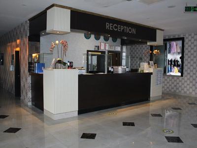 Moderne Hotelrezeption mit schwarzem Tresen, Beistelltisch und glänzendem Marmorfußboden.