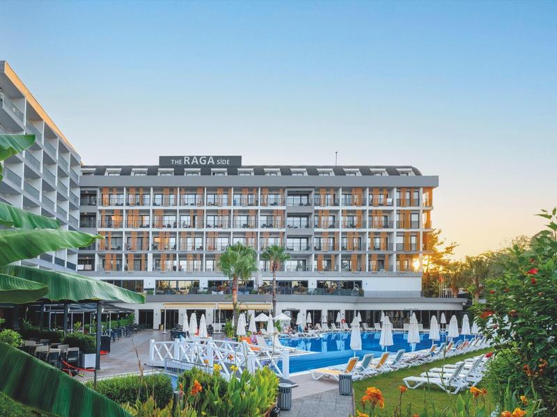 Moderner Hotelkomplex mit Außenpool und Liegestühlen bei Sonnenuntergang.