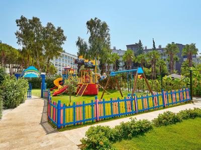 Colorful children's playground with slides and swings in a well-maintained garden area.
