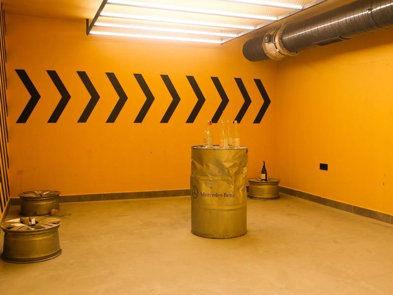 Lege kamer met oranje muren en metalen vaten op de vloer