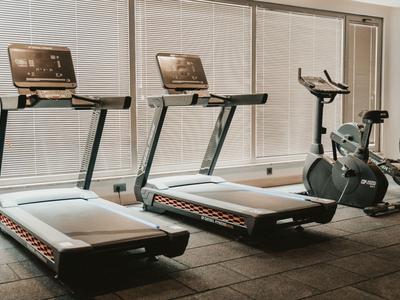 Modern exercise machines in a bright gym with large windows