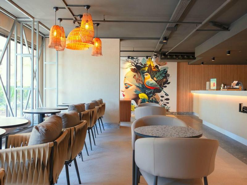 Modernes Café mit bequemen Stühlen, Holztischen und warmem, orangefarbenem Licht.