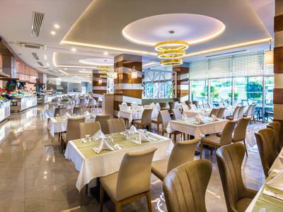Elegantes Restaurant mit gedeckten Tischen, braunen Stühlen und moderner Deckenbeleuchtung.