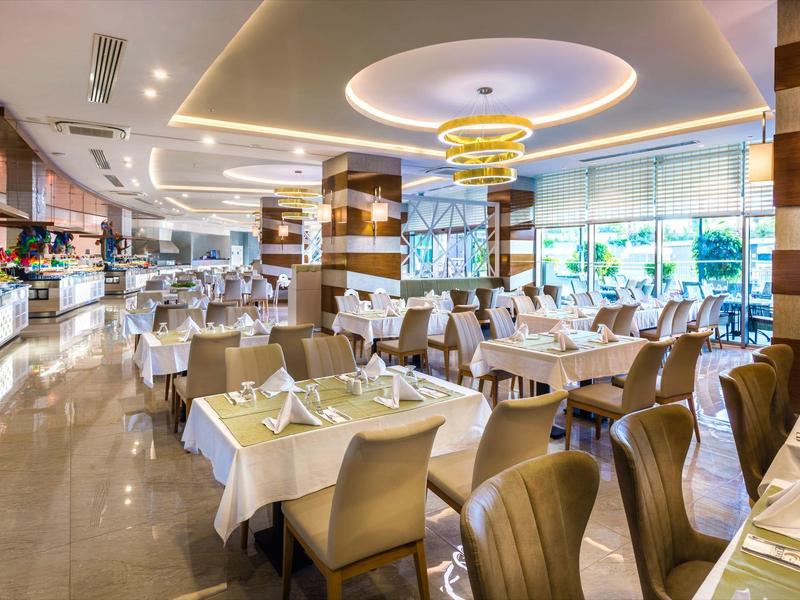 Un elegante restaurante de hotel luminoso con mesas preparadas y sillas modernas.