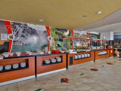 Grand buffet avec divers plats et assiettes dans une salle à manger moderne.