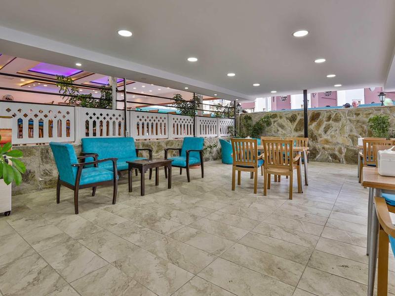 Terrasse couverte moderne avec fauteuils et tables dans un hôtel
