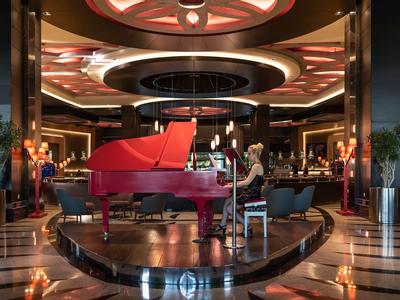 Eleganckie wnętrze lobby hotelowego z czerwonym fortepianem i stylową atmosferą